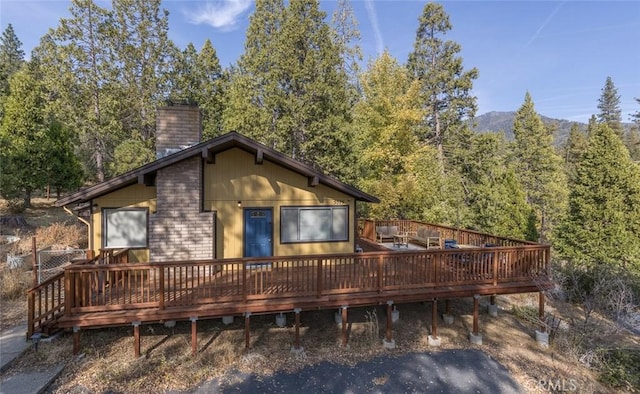 rear view of property featuring a deck with mountain view