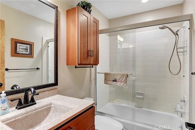 full bathroom with toilet, bath / shower combo with glass door, and vanity