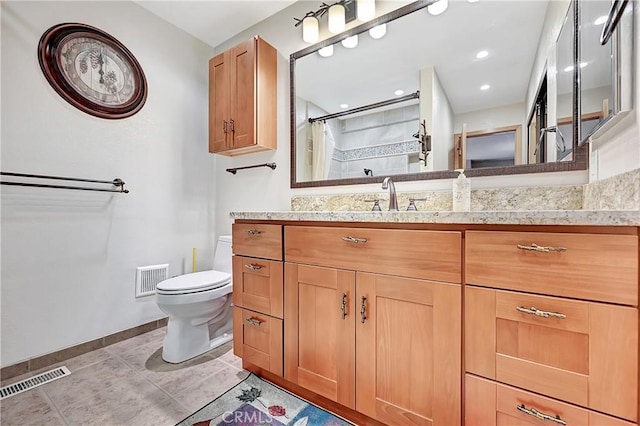 bathroom featuring toilet, walk in shower, vanity, and tile patterned flooring