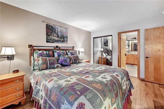 bedroom with a closet, ensuite bathroom, and light hardwood / wood-style floors