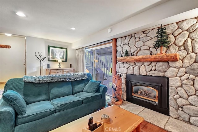 living room featuring wood-type flooring and a stone fireplace