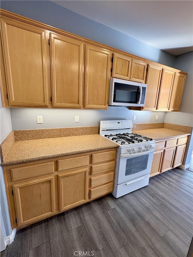 kitchen with dark hardwood / wood-style floors, light brown cabinetry, and gas range gas stove