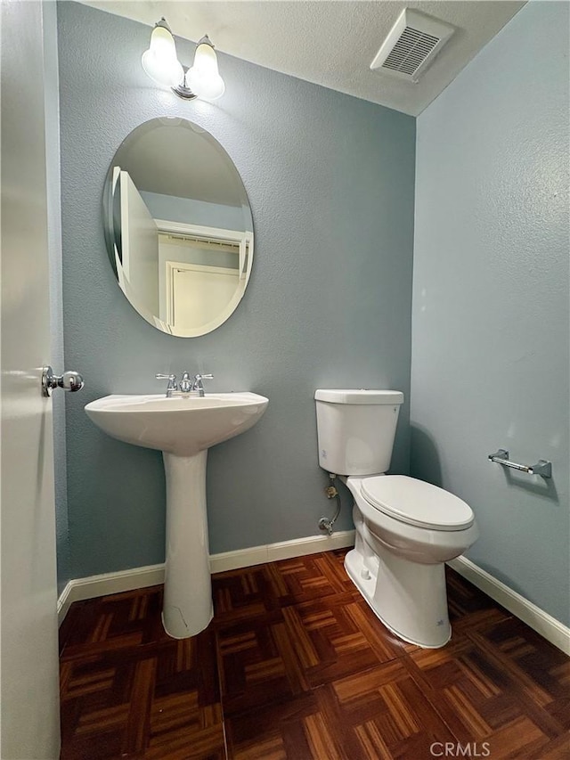 bathroom with parquet flooring and toilet