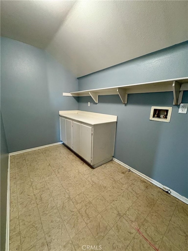 laundry room with cabinets, hookup for a washing machine, and a textured ceiling