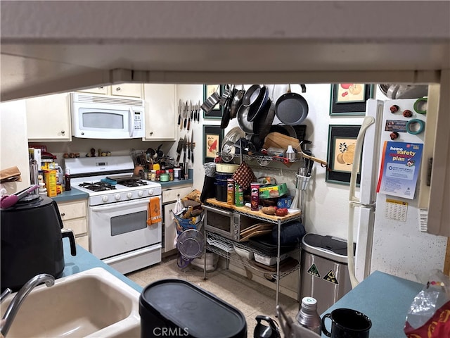 kitchen with white cabinets, white appliances, and sink