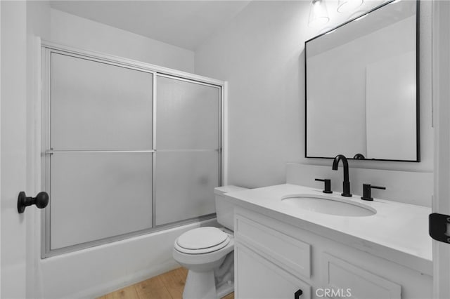 full bathroom with vanity, toilet, combined bath / shower with glass door, and wood-type flooring