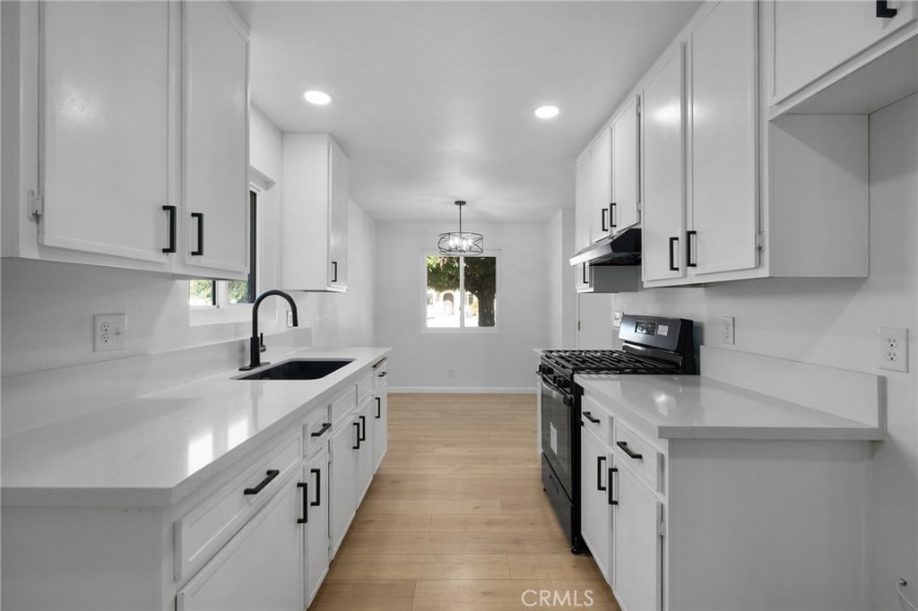 kitchen featuring white cabinets, a healthy amount of sunlight, and black range with gas cooktop