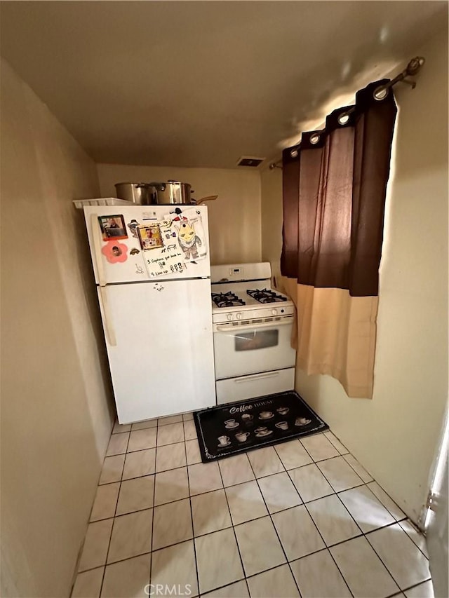 kitchen with light tile patterned floors and white appliances