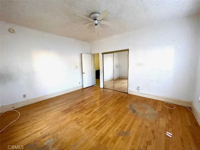 unfurnished bedroom with ceiling fan, light hardwood / wood-style floors, and a textured ceiling