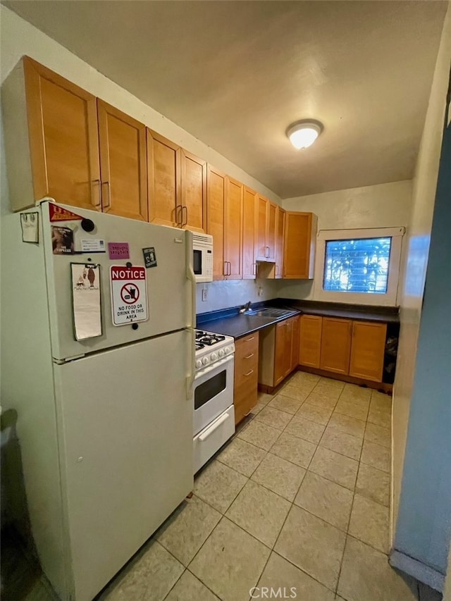 kitchen with white appliances, sink, and light tile patterned floors