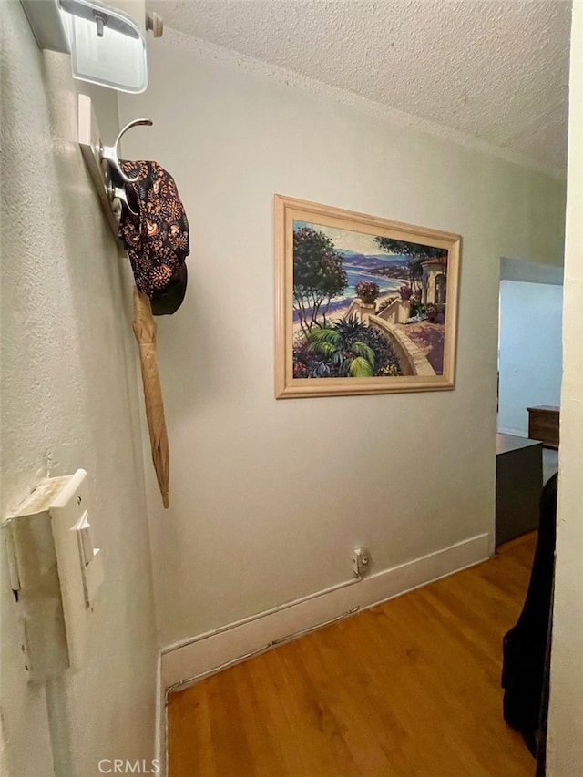 corridor featuring a textured ceiling and light hardwood / wood-style flooring