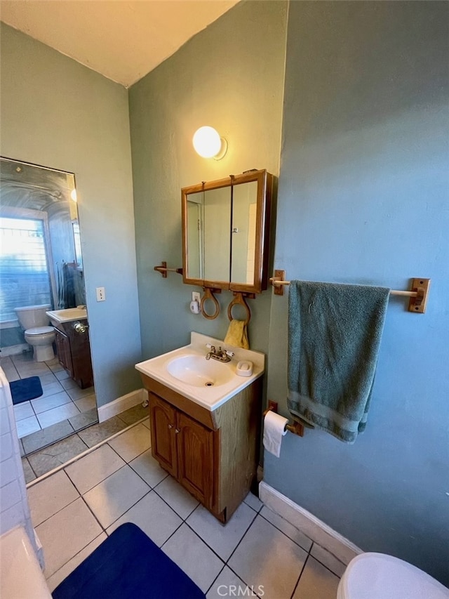 bathroom with tile patterned flooring, vanity, and toilet