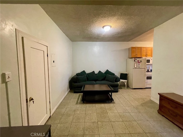 living room featuring light tile patterned flooring and a textured ceiling