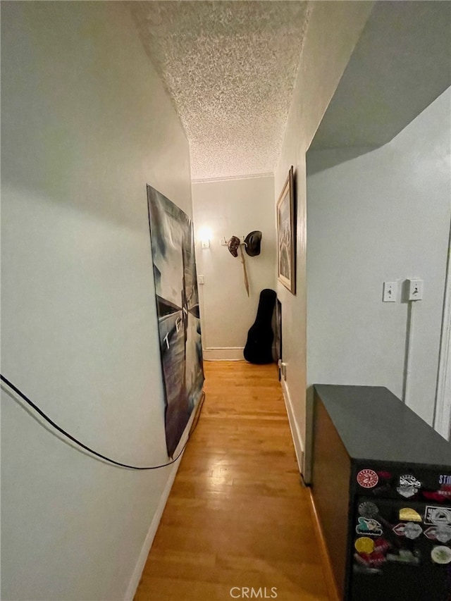 hall featuring hardwood / wood-style floors and a textured ceiling