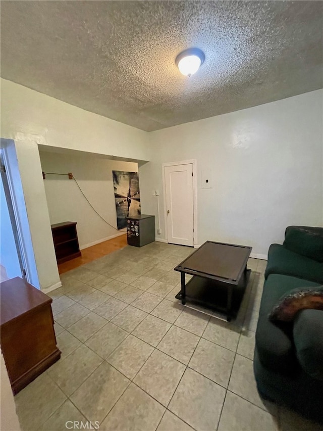 tiled living room featuring a textured ceiling