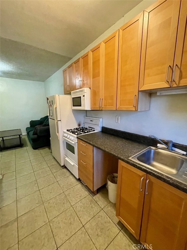 kitchen with light tile patterned flooring, white appliances, and sink