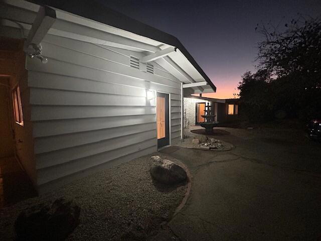 property exterior at dusk with a patio area