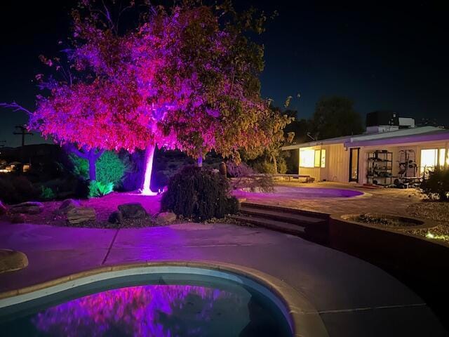 pool at twilight featuring a patio area