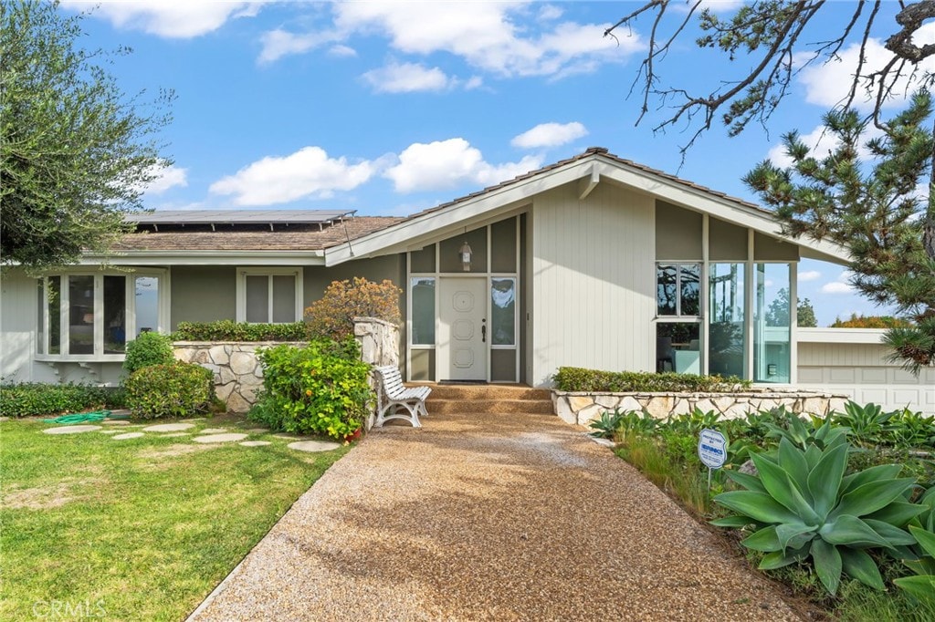 exterior space with a front yard and solar panels