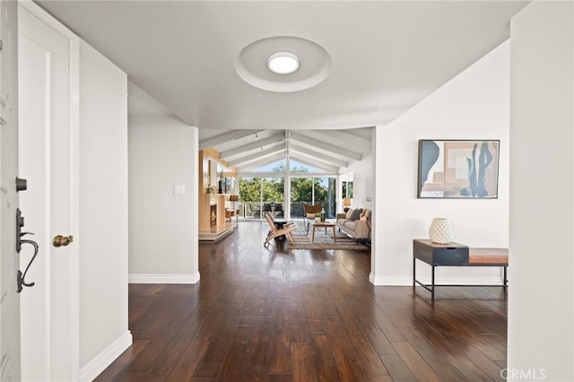 corridor featuring dark hardwood / wood-style flooring and vaulted ceiling