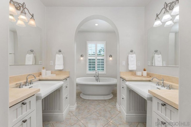 bathroom featuring a tub to relax in, tile patterned flooring, and vanity