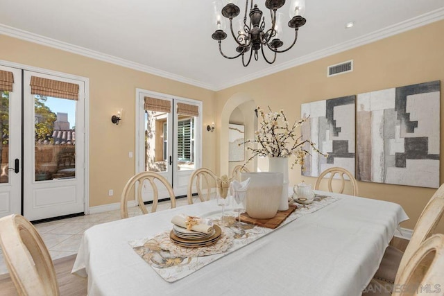 dining area with crown molding, light tile patterned floors, and an inviting chandelier