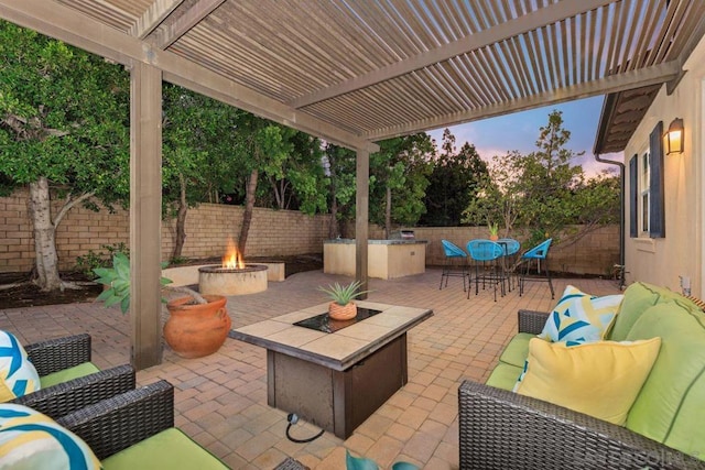 patio terrace at dusk featuring a pergola and an outdoor living space with a fire pit