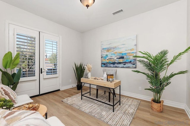 office space with french doors and light hardwood / wood-style flooring