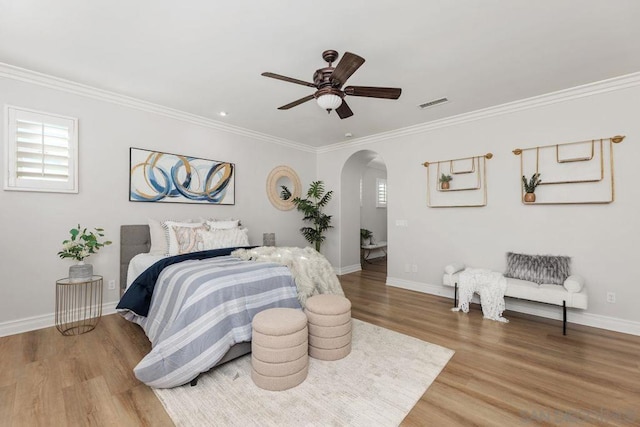 bedroom with ceiling fan, wood-type flooring, and multiple windows