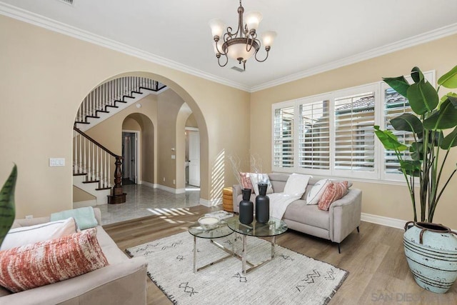 living room with crown molding, a chandelier, and light wood-type flooring