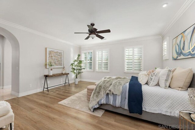 bedroom with ceiling fan, crown molding, and wood-type flooring