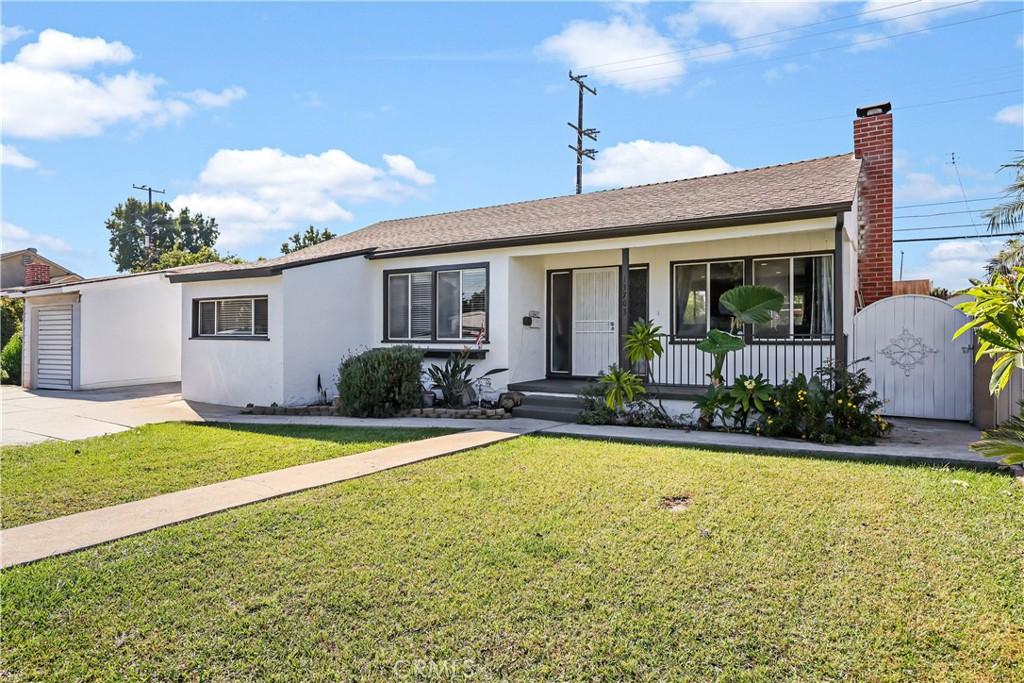 single story home featuring a porch and a front lawn