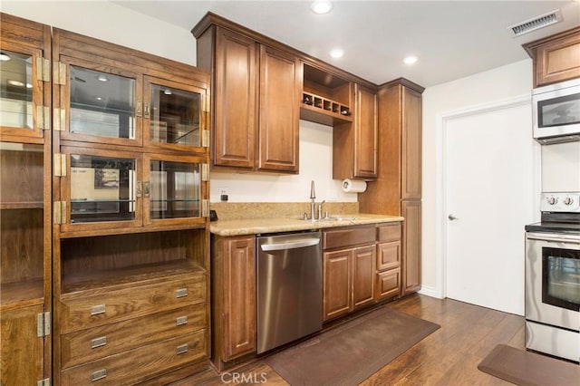 kitchen featuring light stone countertops, sink, dark hardwood / wood-style floors, and appliances with stainless steel finishes