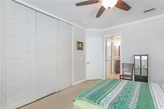 bedroom featuring carpet, ensuite bathroom, ceiling fan, and ornamental molding