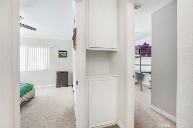 hallway featuring light carpet and crown molding