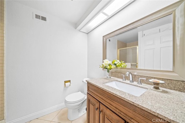 bathroom featuring tile patterned floors, vanity, toilet, and walk in shower