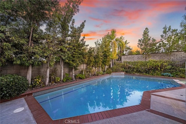 view of pool at dusk