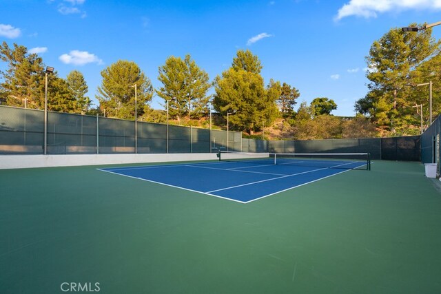 view of tennis court featuring basketball hoop