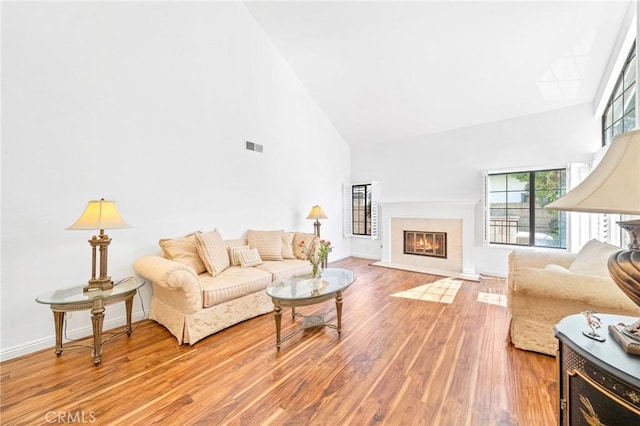 living room featuring light wood-type flooring and high vaulted ceiling