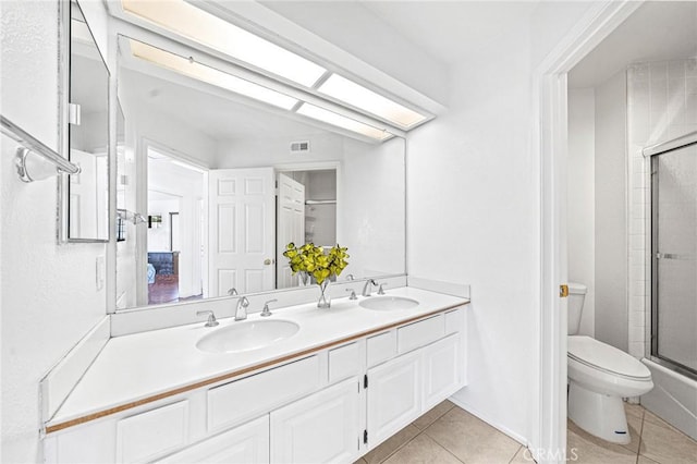 full bathroom with tile patterned flooring, vanity, toilet, and combined bath / shower with glass door