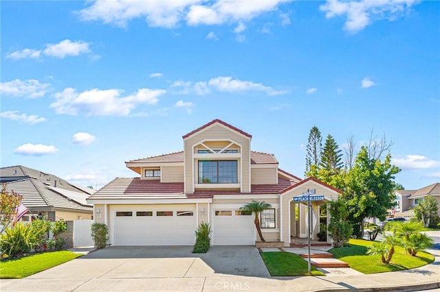 view of front of home featuring a garage, a tile roof, and concrete driveway