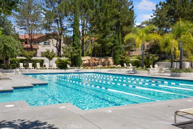 pool with a patio and fence