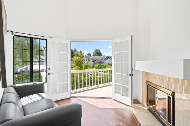 interior space featuring a tile fireplace, french doors, and plenty of natural light