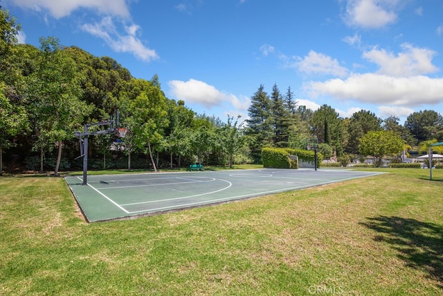 view of sport court with a yard