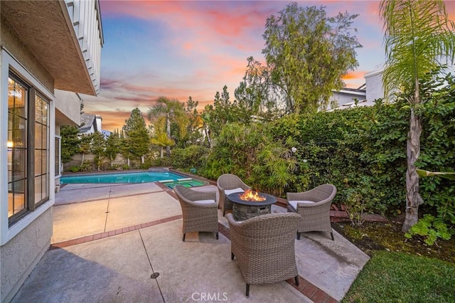 view of patio featuring a fenced in pool and a fire pit