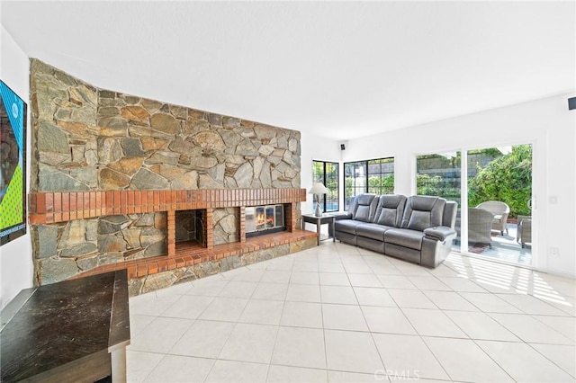 tiled living room with a stone fireplace