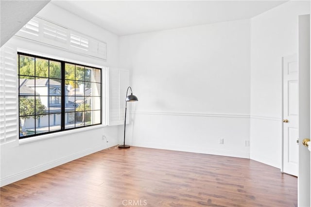 empty room featuring baseboards and wood finished floors