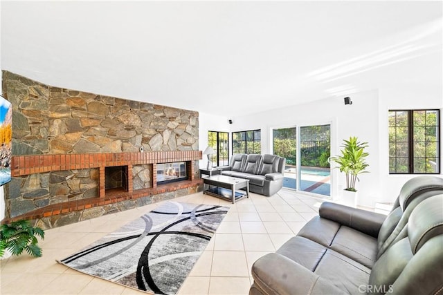 living area with tile patterned floors and a stone fireplace