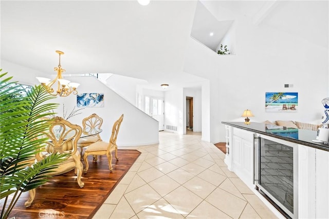 interior space featuring light tile patterned floors, white cabinetry, visible vents, hanging light fixtures, and an inviting chandelier