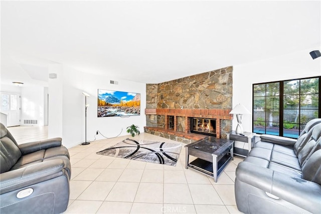 tiled living room featuring a fireplace and visible vents